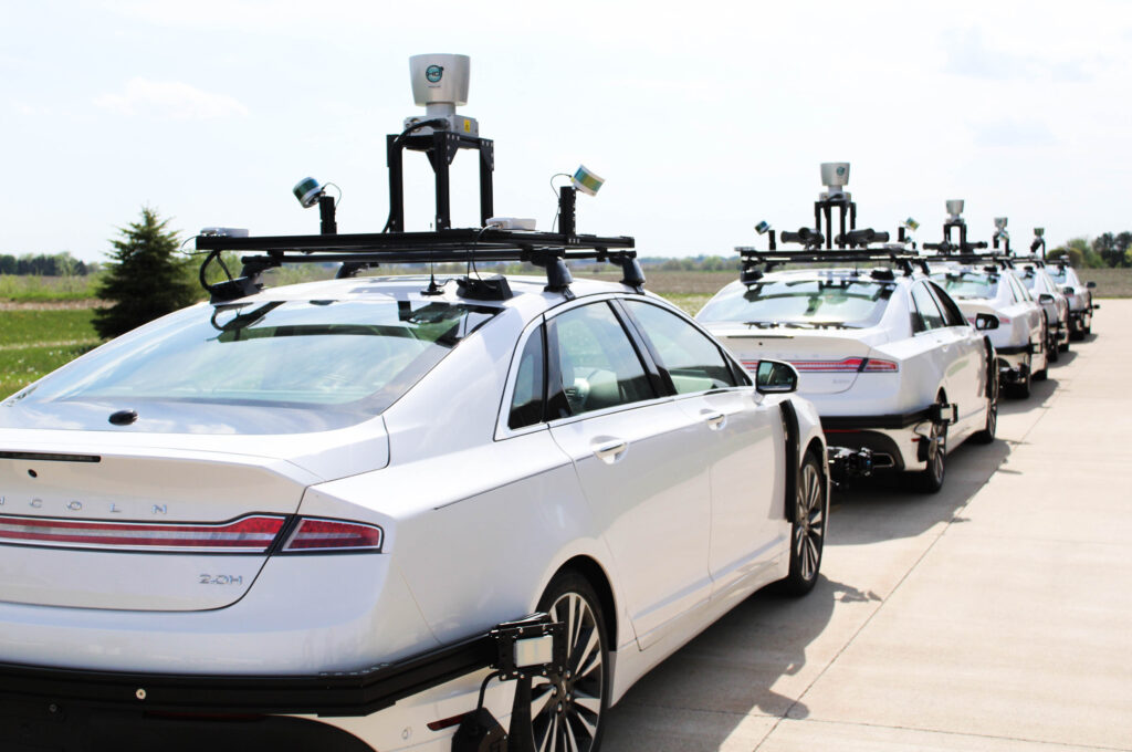 A line of white connected autonomous vehicles