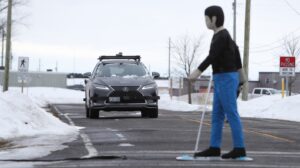 An autonomous vehicle is stopped at a simulated crosswalk in winter conditions. 