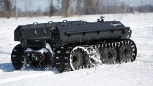 An autonomous treaded vehicle works through snowy conditions. 