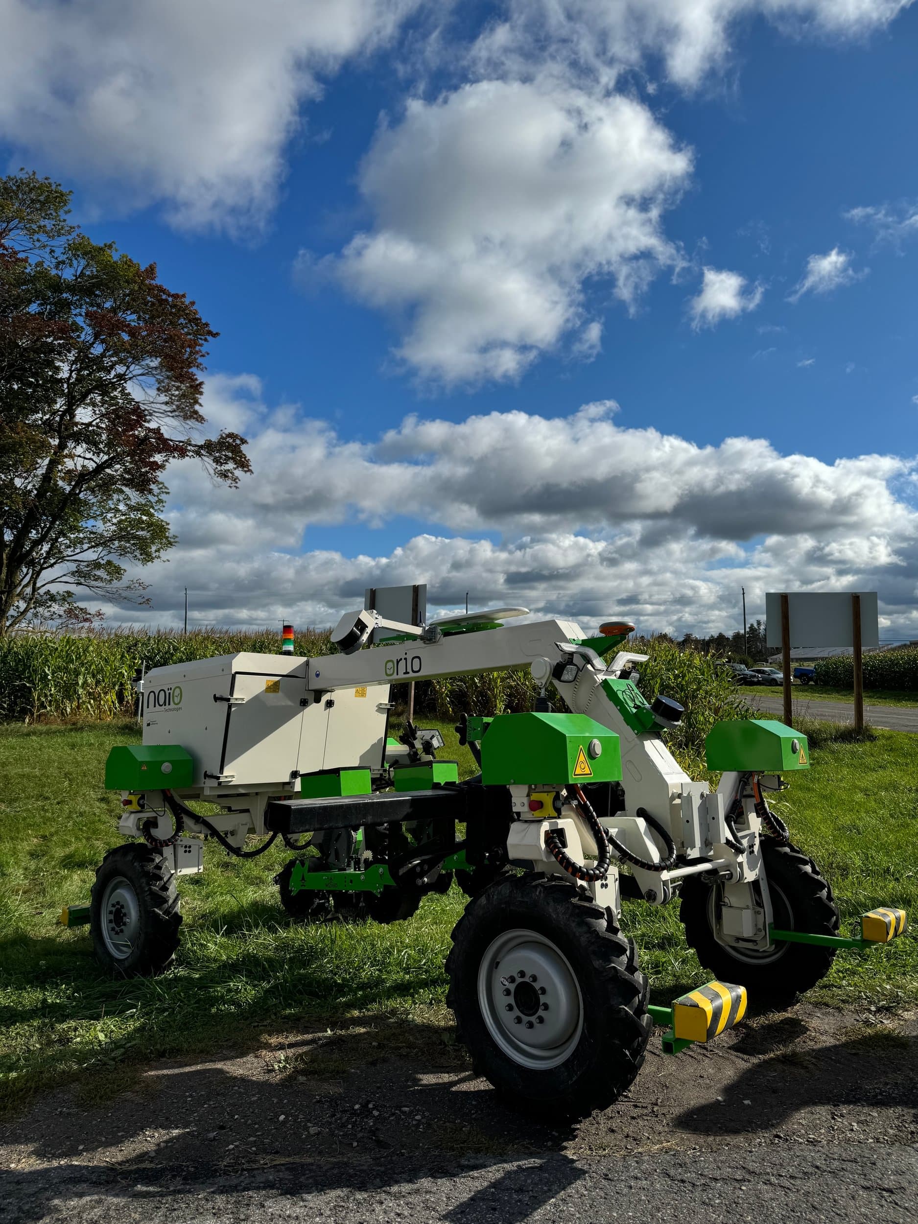 Agtech robot on grass with blue sky and clouds overhead